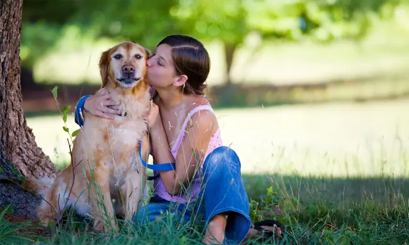 Woman kissing her dog